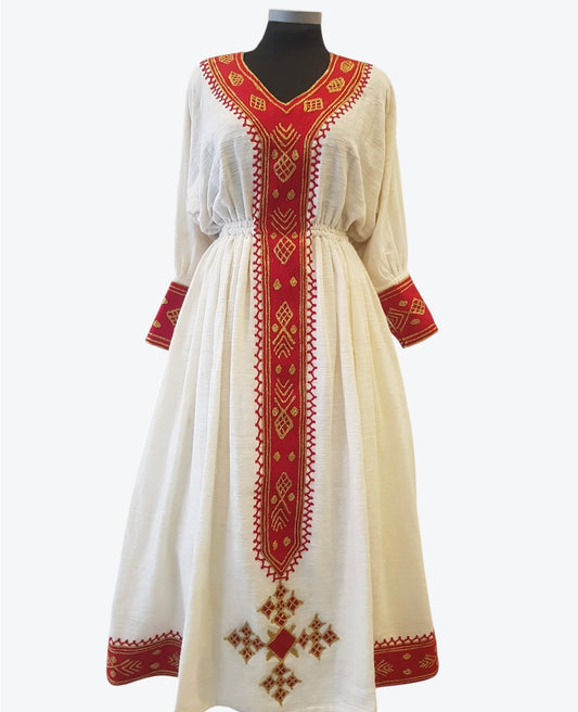 A long white Ethiopian Outfit with red and gold embroidered patterns, displayed on a black mannequin against a light gray background.