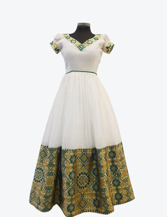 A white A-line maxi Ethiopian Outfit with short puff sleeves, featuring a green and gold geometric patterned border on the hem and neckline, displayed on a black mannequin against a light gray background.