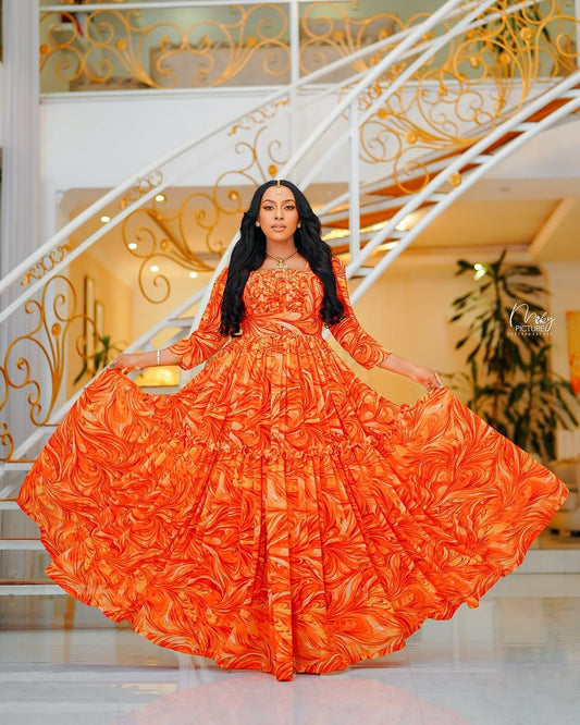 Woman in an orange habesha chiffon standing in a decorated interior setting