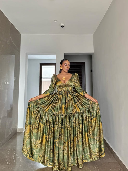 Woman wearing a green and yellow patterned Green Flowing Habesha Shiffon Dress in a modern hallway.