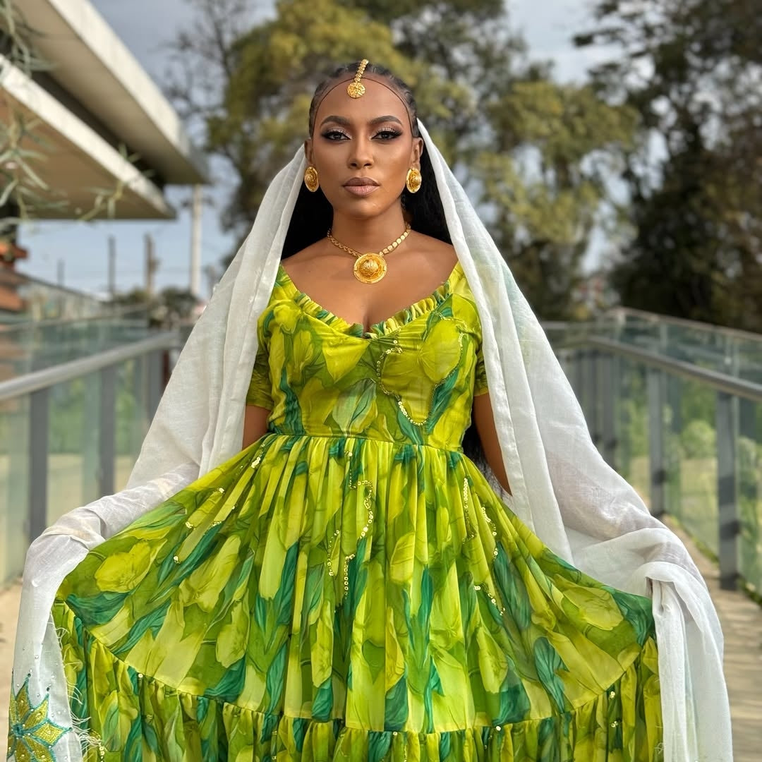 Woman wearing a Green Habesha Shiffion with a white veil outdoors