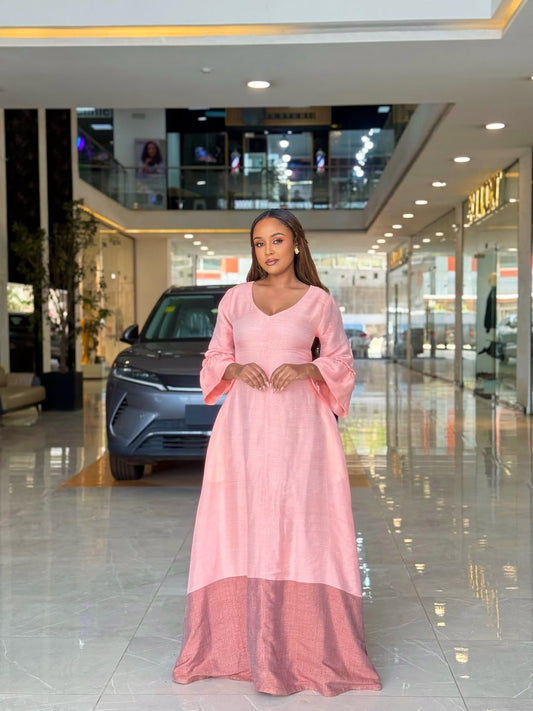 Woman in a pink Ethiopian libs  standing in a car showroom