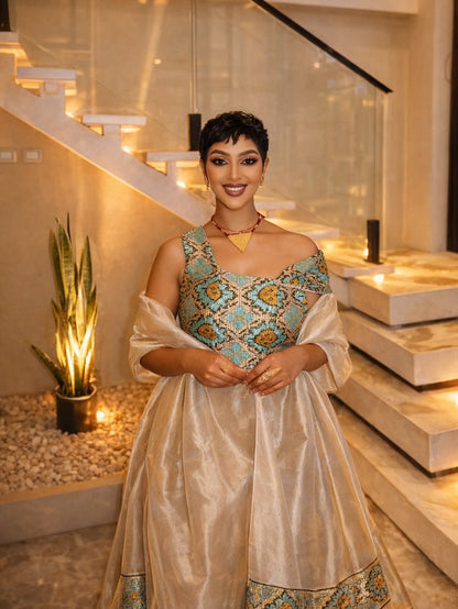 Woman in a traditional Habesha Libs standing in a modern indoor setting with stairs and decorative elements.