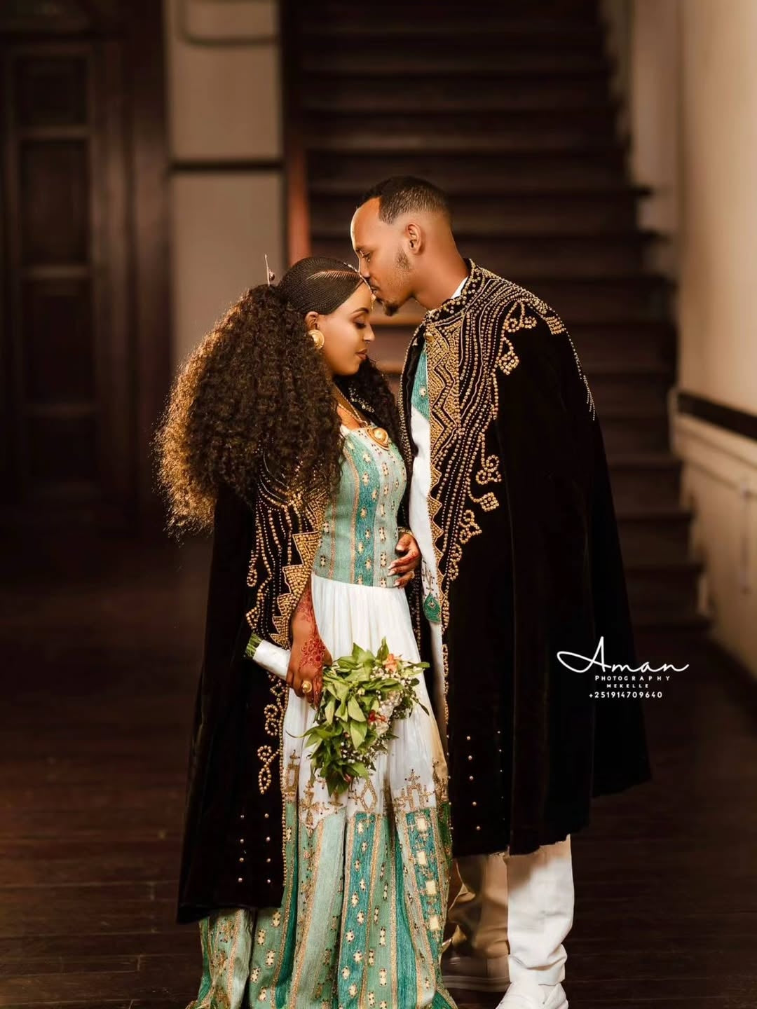 Couple in traditional attire standing close together on a staircase