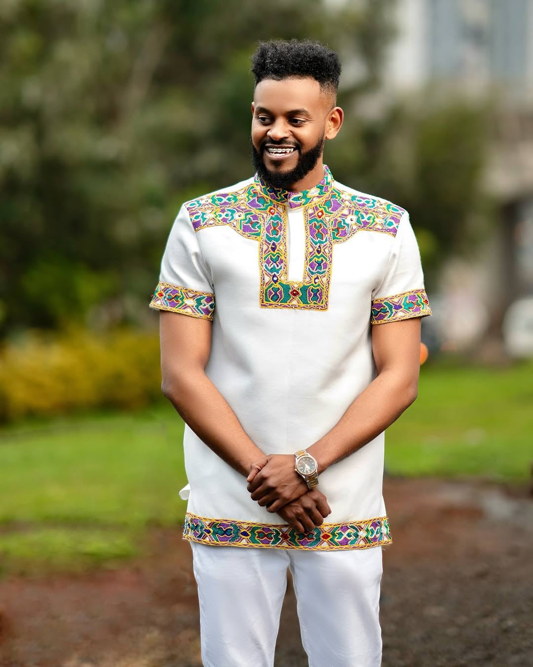Man wearing a Habesha Men’s Outfit embroidered  in an outdoor setting