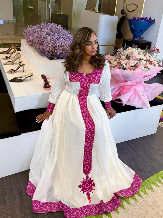 Woman in a white and pink traditional zuria standing in a store with floral displays.