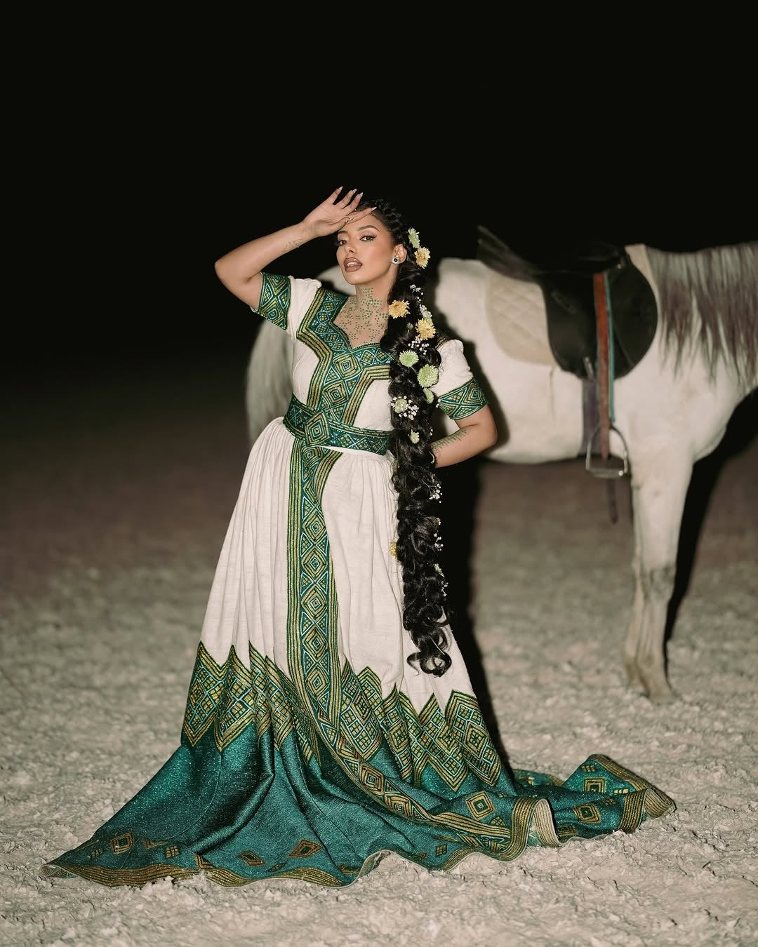 Woman in a traditional green and white Ethiopian Habesha Wedding Dress with a horse in the background