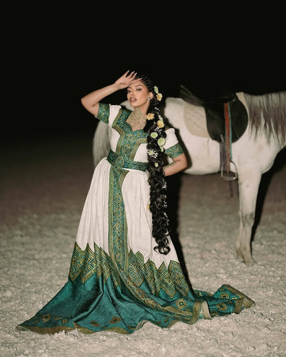 Woman in a traditional green and white Ethiopian Habesha Wedding Dress with a horse in the background