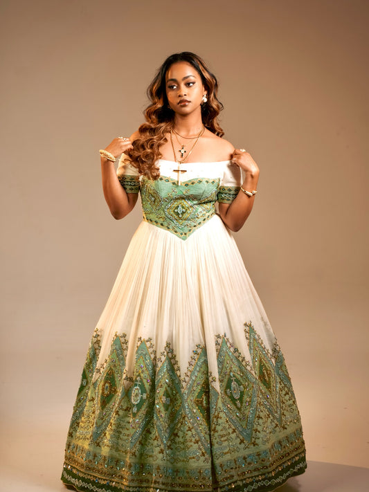 Woman wearing a green and white patterned Ethiopian National Dresses against a beige background