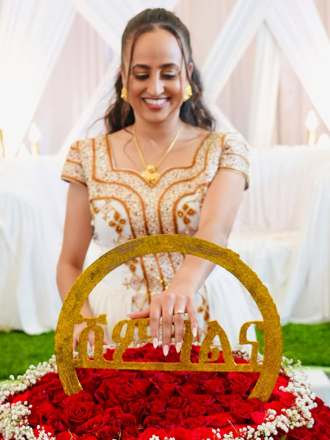 Woman in a decorated setting with flowers and Habesha Kemis