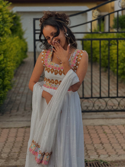 Woman in traditional Ethiopian Dress with floral patterns outdoors