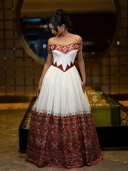 Woman wearing a white and red patterned dress standing in front of a mirror.