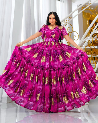 Woman in a vibrant pink habesha chiffion with gold patterns standing in a well-lit room.
