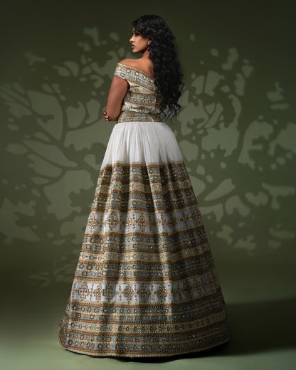Woman wearing a patterned off-shoulder top and long Ethiopia traditional dress against a green background
