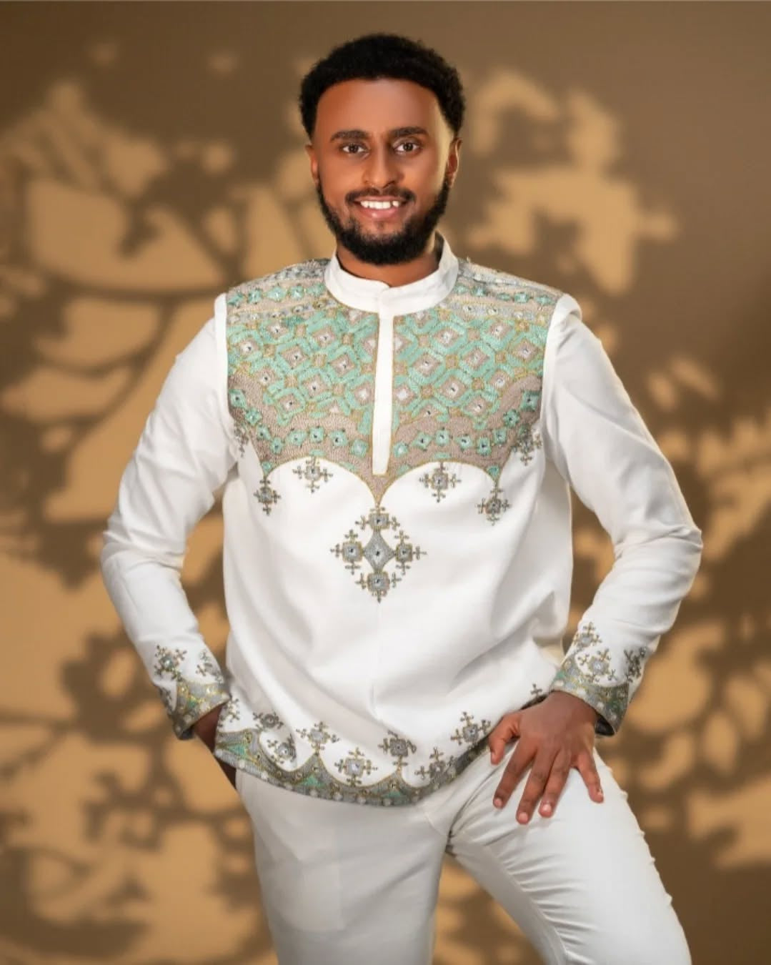 Man wearing a Men’s Traditional Shirt embroidered shirt with green patterns against a brown background