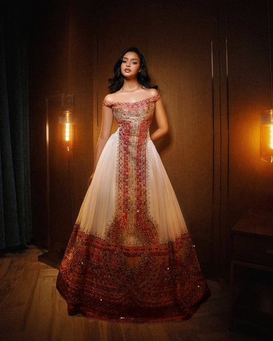 Woman wearing a traditional embroidered Ethiopian National Dresses in a dimly lit room with warm lighting.
